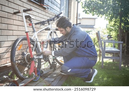 Similar – Image, Stock Photo Repairman fixing bicycle wheel in workshop