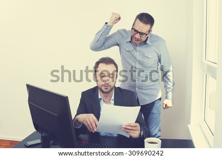 Businessman in office with his angry employer.
