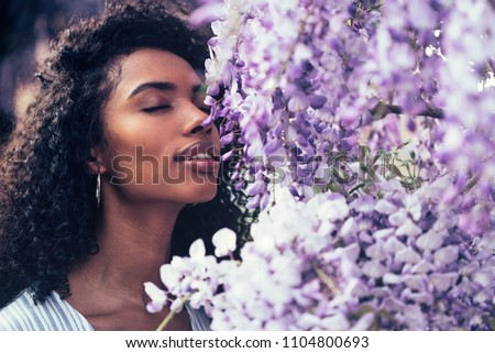 Image, Stock Photo Cheerful black woman smelling aromatic flower in hothouse