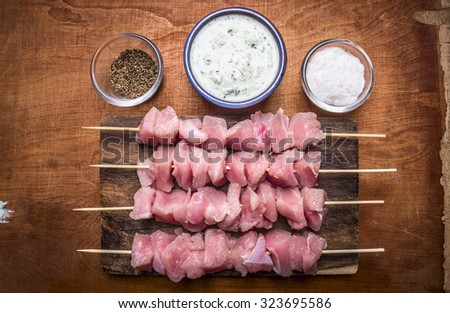 seasoning sauce for cooking a turkey on skewers on a wooden background top view