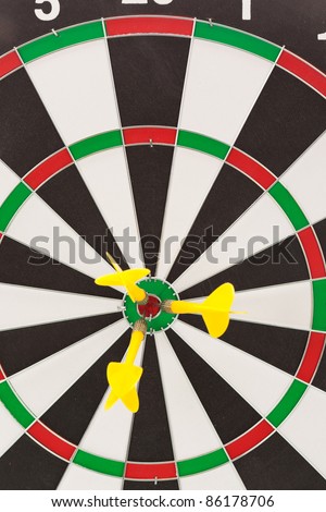 Shallow depth of field shot of darts in bullseye on dartboard