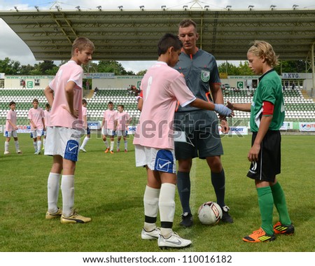 KAPOSVAR, HUNGARY - JULY 21: Team captains shake hands at the VIII. Youth Football Festival U14 match Tirgu Mures (pink) (ROM) vs. Kaposvar (green)(HUN) on July 21, 2012 in Kaposvar, Hungary