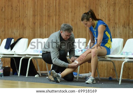 KAPOSVAR, HUNGARY - JANUARY 23: The doctor heals it the Zsofia Harmath wound at the Hungarian NB I. League woman volleyball game Kaposvar vs Miskolc, January 23, 2011 in Kaposvar, Hungary.