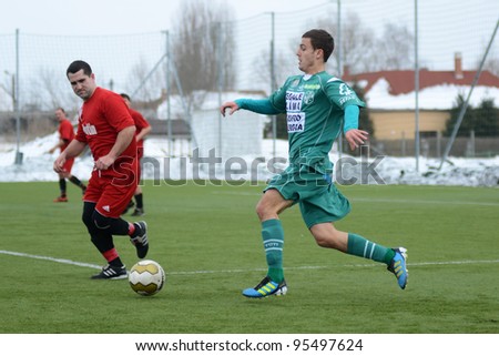 KAPOSVAR, HUNGARY - FEBRUARY 18: Unidentified players in action at a friendly soccer game Kaposvar (green) vs. Dombovar (red) - February 18, 2012 in Kaposvar, Hungary.