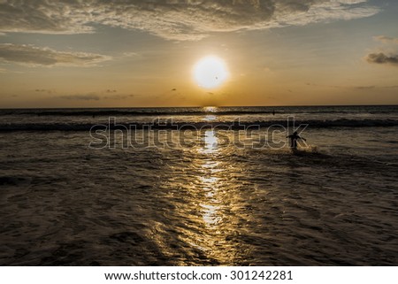 Freedom Pacific sunset. Photography that captures the sunset on the pacific coast of Ecuador, while a native runs freely in the middle of the sea.