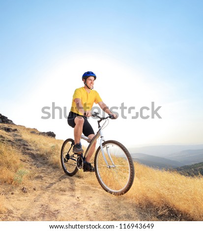 Panning shot of a person riding a bike outdoors with some motion blur shot with a tilt and shift lens