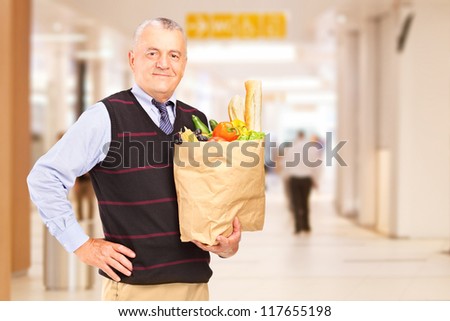 Gentelman in a shopping mall holding a bag with groceries