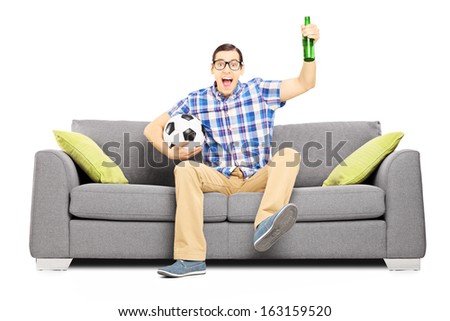 Excited male sport fan with ball and beer watching sport isolated on white background
