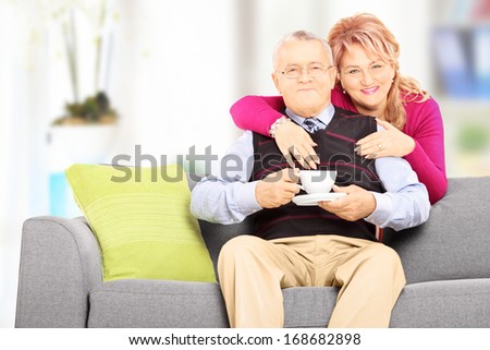 Middle aged couple posing during a coffee break at home