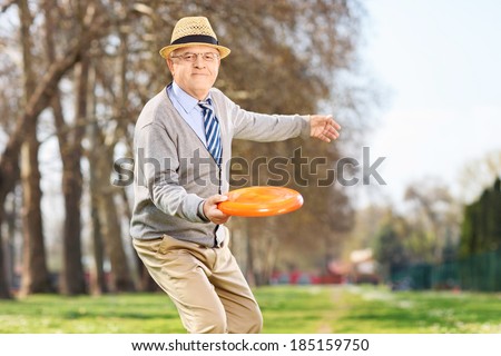 Senior man throwing a frisbee disk in a park