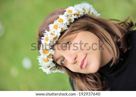 Beautiful woman with daisy hair wreath posing outdoors