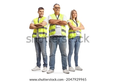 Full length portrait of two men and a woman wearing a reflective safety vests and posing with crossed arms isolated on white background