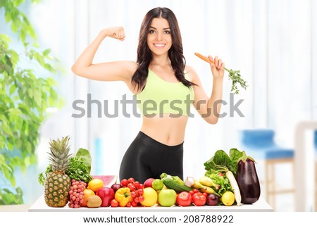 Woman standing behind a table with fruits and vegetables at home
