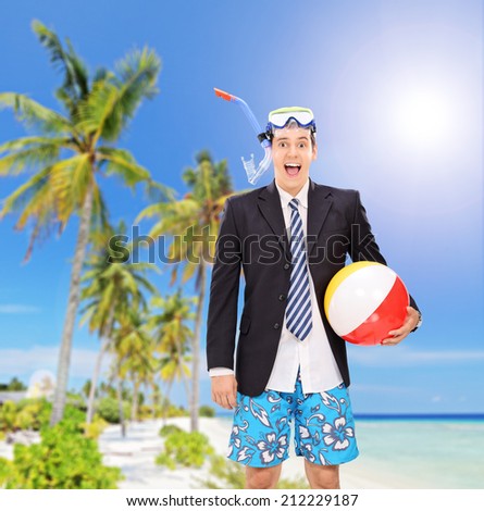 Man standing on beach with snorkel and beach ball shot with a tilt and shift lens