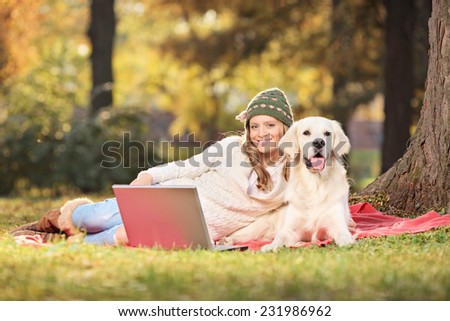 Woman enjoying a picnic with her dog in park in the autumn