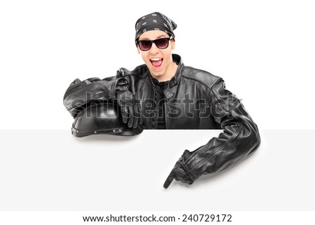 Young male biker in leather jacket pointing on a billboard isolated on white background