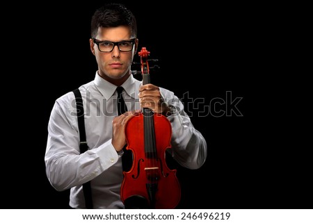 Young musician posing with a violin on black background