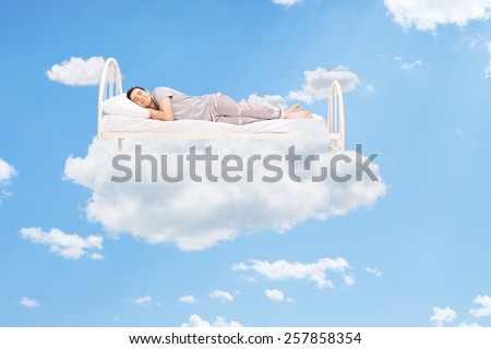 Man sleeping on a bed in the clouds high up in the sky 商業照片 © 