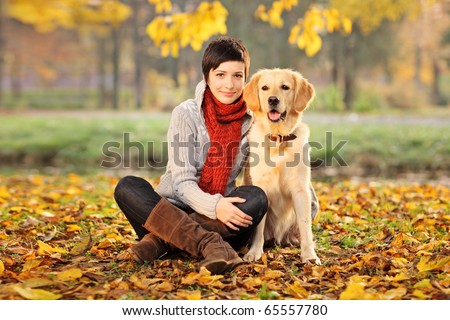 A beautiful woman and his dog (Labrador retriever) posing outside