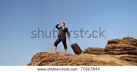 Full length portrait of a lost businessman with a suitcase searching for a way