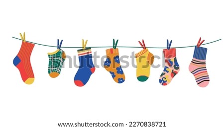 Socks on a rope with colored clothespins. Dry a cotton or wool sock and hang it on a clothesline with clothespins. Baby socks with textures and patterns vector cartoon. Illustration of woolen and cott