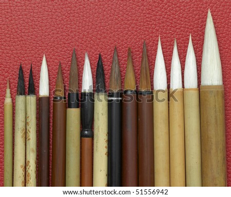 Set of old chinese brushes on red background