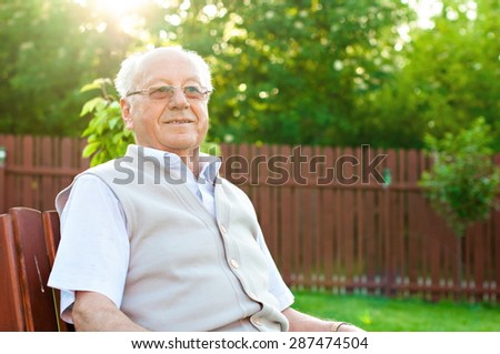 Closeup profile on a smiling old man sitting