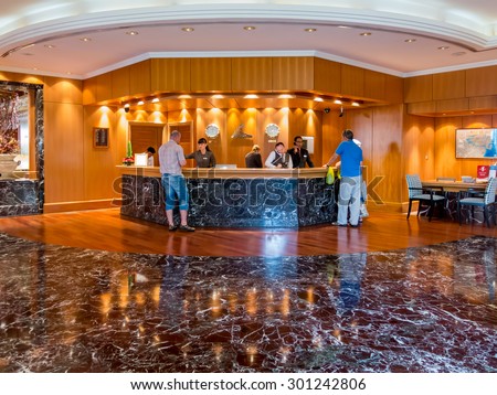 DUBAI, UNITED ARAB EMIRATES (UAE) - JAN 25, 2014: Receptionists and guests at reception desk in hotel beach resort in Dubai, United Arab Emirates