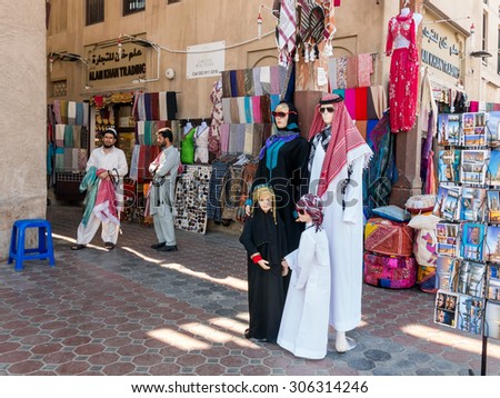 DUBAI, UNITED ARAB EMIRATES - JAN 26, 2014: Shop and sellers in the ancient covered textile souq Bur Dubai in the old city centre of Dubai, United Arab Emirates