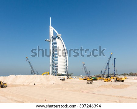 DUBAI, UNITED ARAB EMIRATES - JAN 25, 2014: Cranes and work in progress on construction site near Burj al Arab Hotel, Jumeirah Beach in the city of Dubai, United Arab Emirates