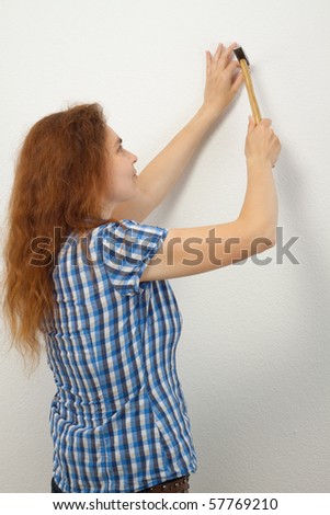 A young woman breaks a nail in the wall