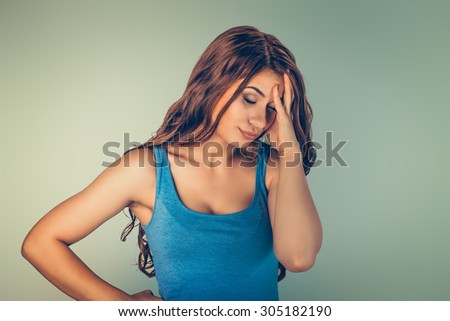 Close up portrait unhappy stressed sad lonely young woman girl female in studio, isolated green background. Negative human emotions facial expression, feeling, body language. Life style stress concept
