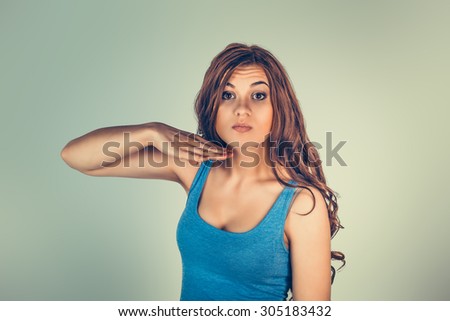 Closeup portrait of angry young woman gesturing with hand to stop talking, cut it out, no or that she will take your head off, isolated green background. Negative emotion, facial expressions, feelings