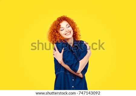  Love yourself concept. Closeup portrait confident smiling woman holding hugging herself isolated yellow wall background. Positive human emotion, facial expression feeling reaction situation attitude 商業照片 © 