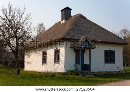 Old clay school-house with straw roof in country