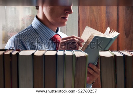 men reading a book next to the bookshelf