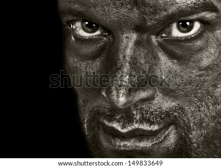 Evil man showing terror emotion and darkness in the intense eyes and sarcasm in the smile. In Black and White.