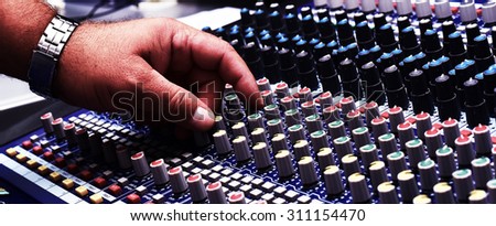 Hand Moving Buttons on Audio Mixer