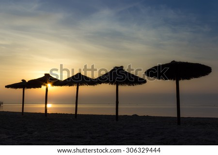Back lighting the sunrise behind the umbrellas in the beach