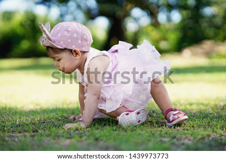 Image, Stock Photo Young toddler standing up looking at a fabric children’s book; eclectic decor with house plants