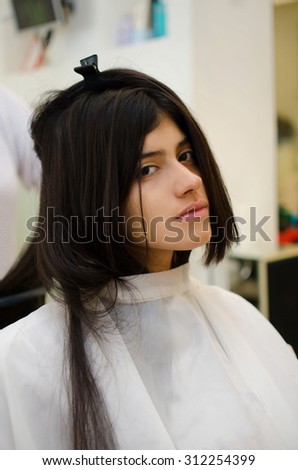 Young latin woman at hairdressing salon being coiffed