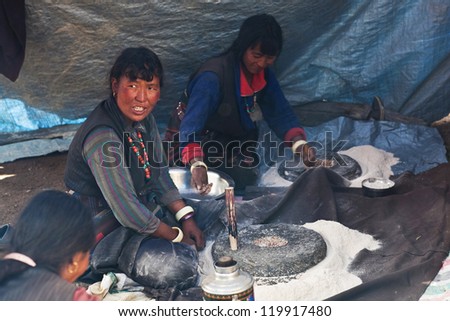 CHARKA, NEPAL - SEPTEMBER 14: unidentified Tibetan women cooking Tibetan dish \'Tsampa\' during Full Moon Festival on September 14, 2011 in Charka Village, Dolpo district, Nepal