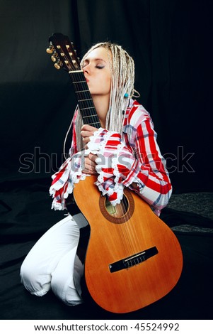 portrait of a beautiful blonde with long pigtails and a guitar