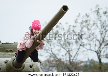 DONETSK, UKRAINE - MAY 9: Kid playing around soviet tanks and artillery during celebration of the Victory Day near 
