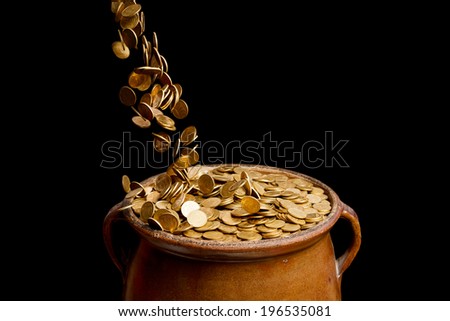 gold coins falling in the vintage pot isolated on black background