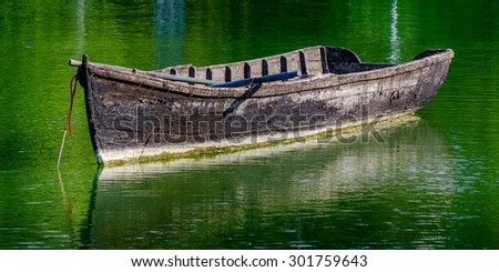 Small boat drifting on a lake in the morning light of the sun.