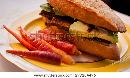 Torta / sub / sandwich with pork and avocado, and a side of carrots