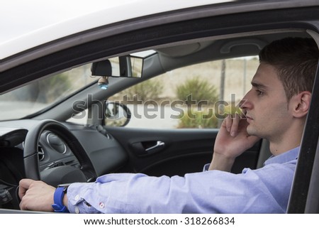 Young driver talking on his cell phone, business - view from outside