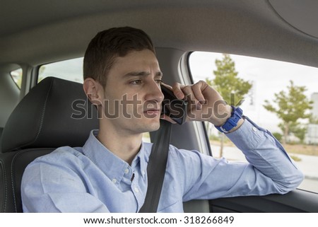 Young driver talking on his cell phone, business - view from inside