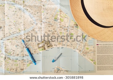 Travel plans, a pen, map and a hat